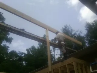 Carpenter setting a ridge beam over a new addition frame — Ice Dam Removal by Roofing Brothers in Interlachen