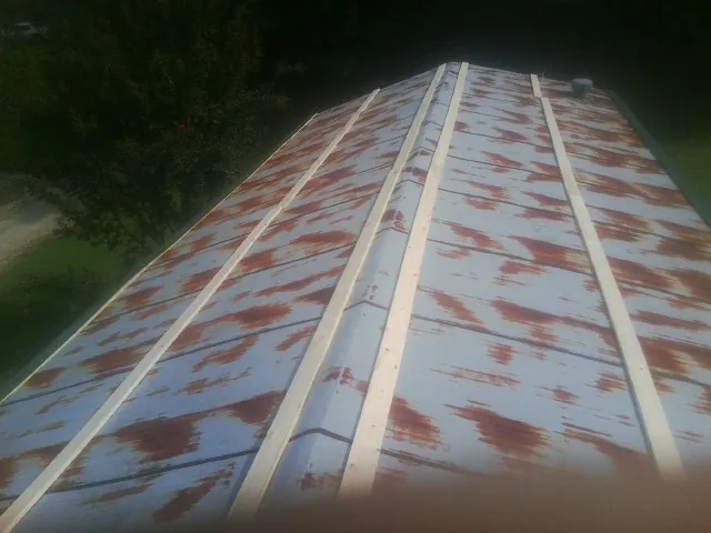 Rusted metal roof panels with new wood purlins before replacement — Storm Damage Roof Repair in Interlachen by Roofing Brothers