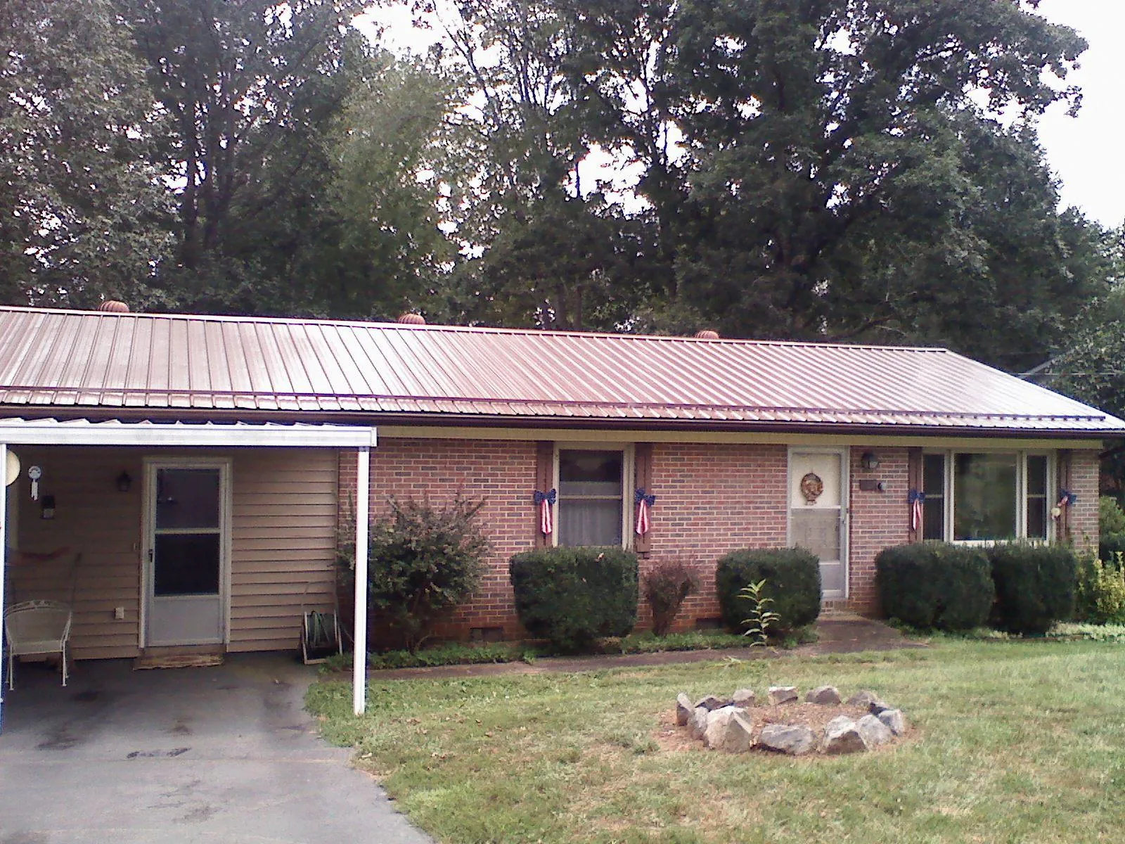 Bronze metal roof and carport on a brick ranch home — Roof Repair work by our crew in Interlachen